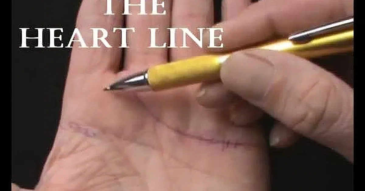 A hand holding a pen points to the heart line on a palm, with text "THE HEART LINE" above.
