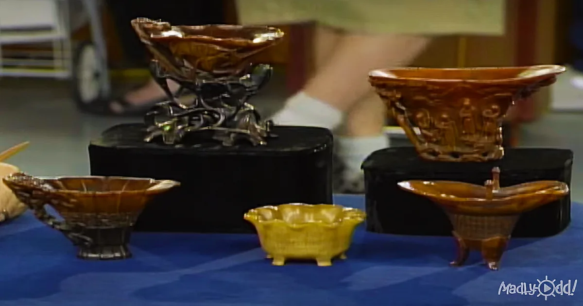 Intricately carved amber bowls and a dragon-shaped stand on a blue table.