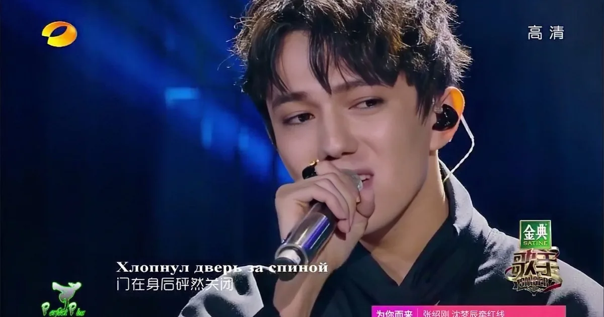 A performer sings into a microphone on stage, with Russian subtitles and Chinese text visible.
