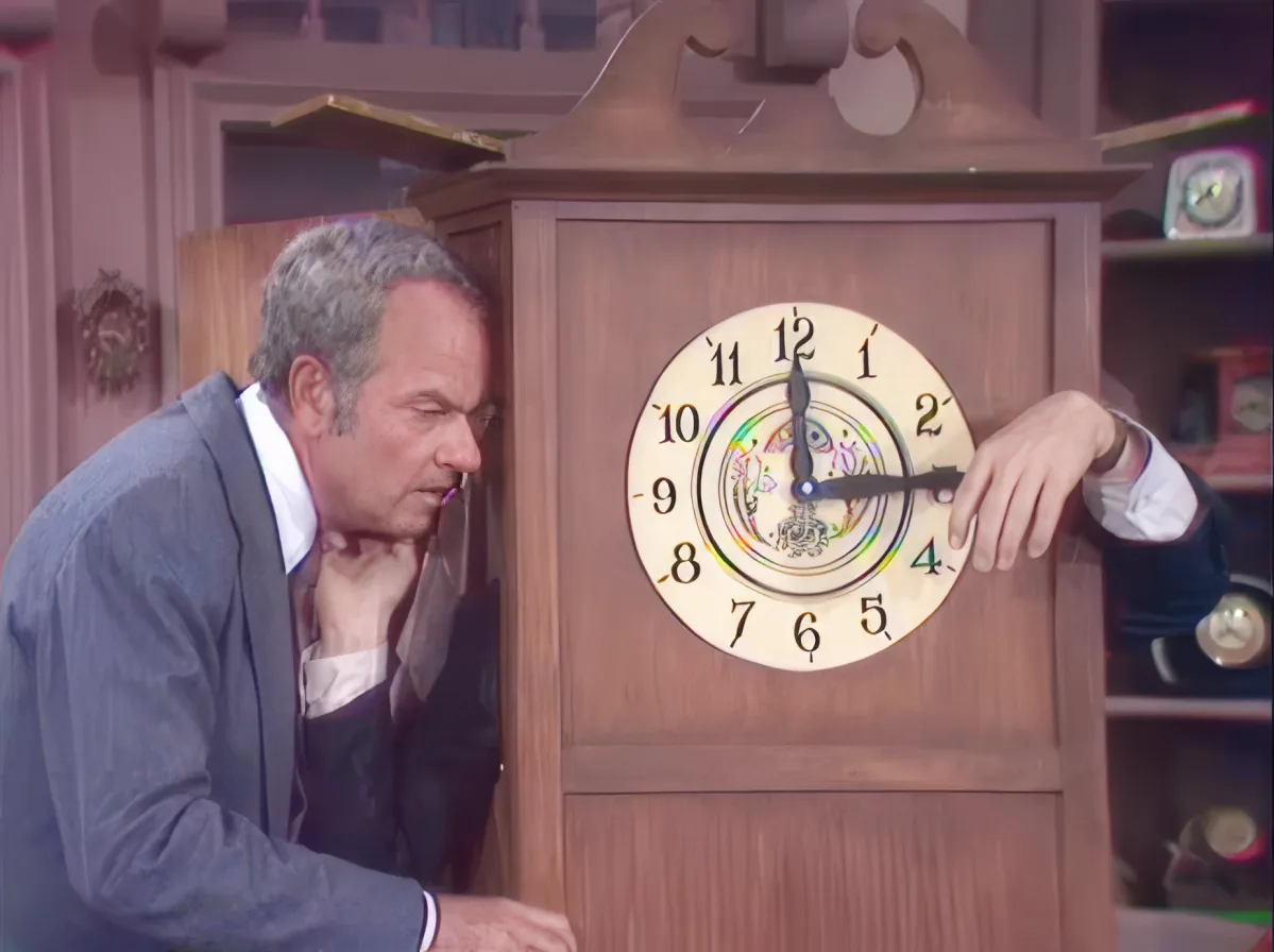 A man leans toward a wooden grandfather clock with a visible pendulum and clock face.