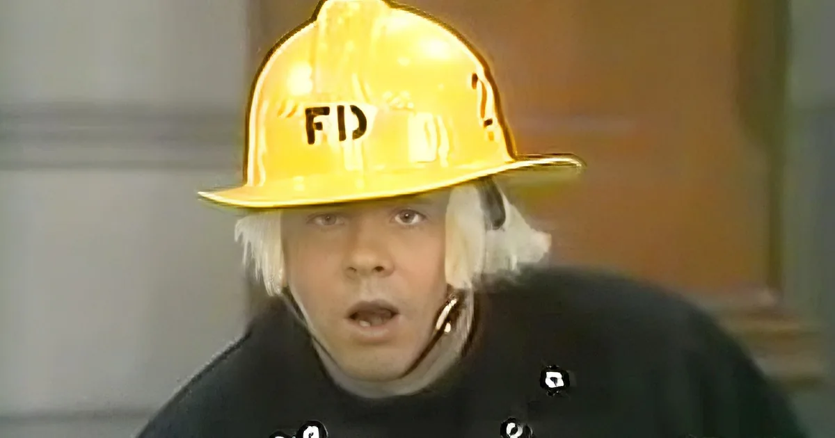 A person wearing a yellow hard hat with "FD" on it, a black shirt, and a white cloth covering their ears.