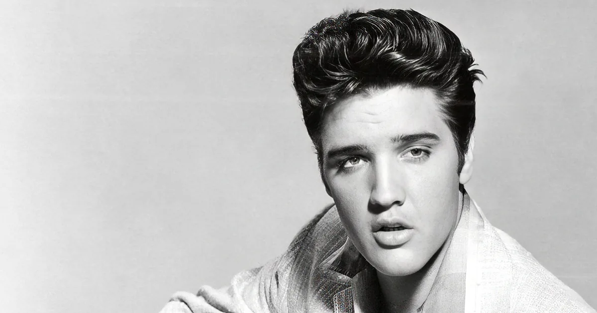 A black-and-white portrait of Elvis Presley with a distinctive hairstyle and a plaid shirt.