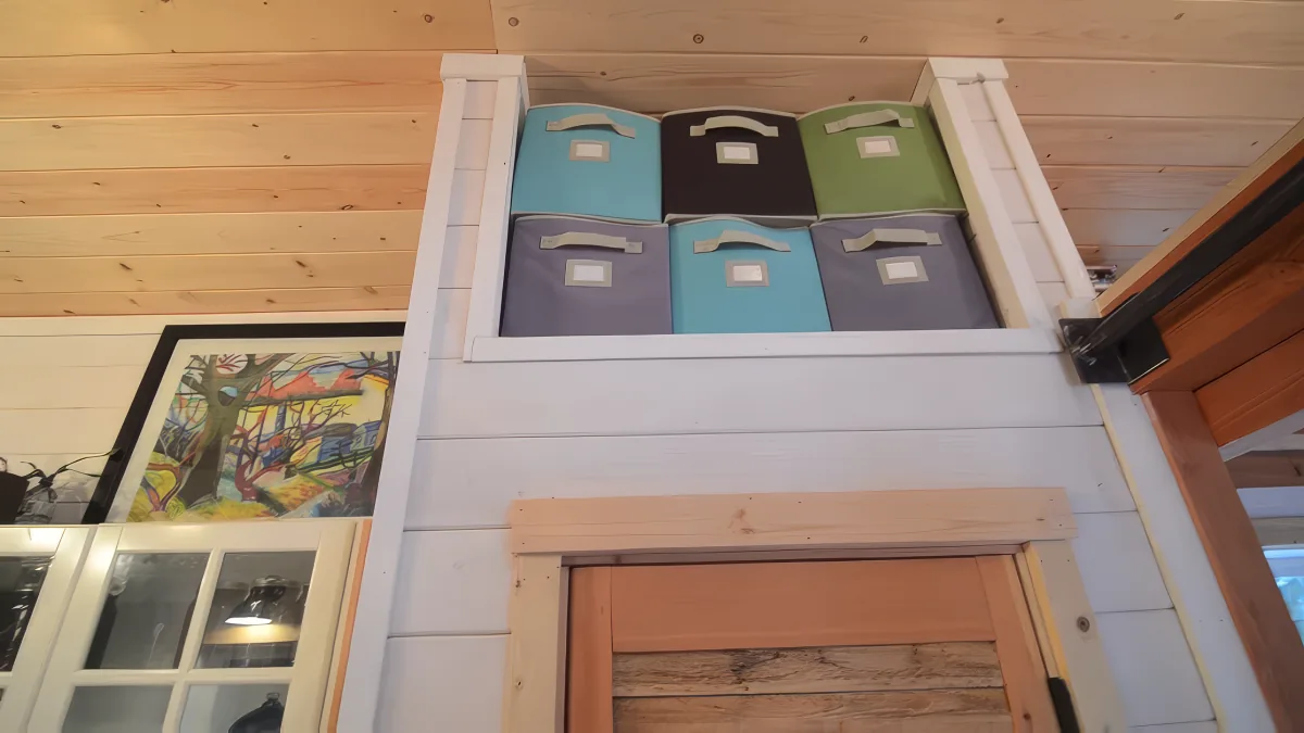 Colorful storage bins in a wooden-framed display on a wall.
