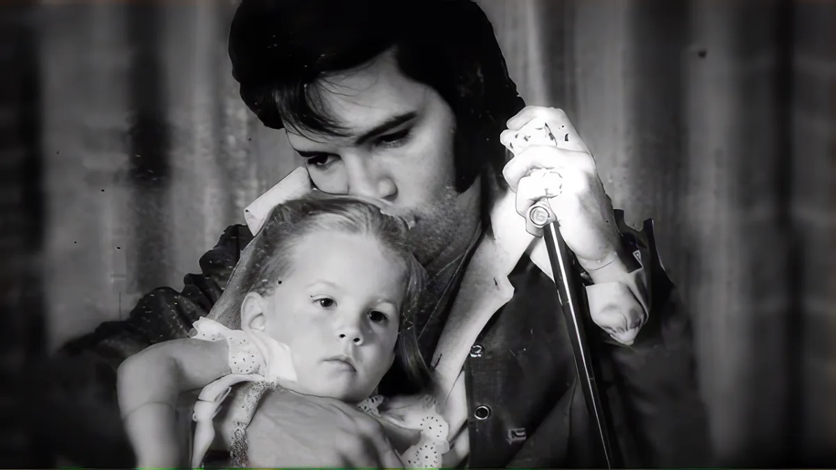 Elvis Presley kisses a baby while holding a microphone, surrounded by collage elements.