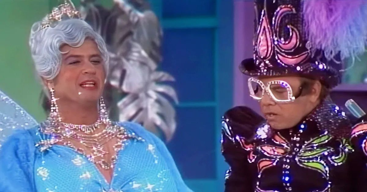 A person in a blue fairy costume with a tiara and another in a black outfit with a colorful hat and glasses.