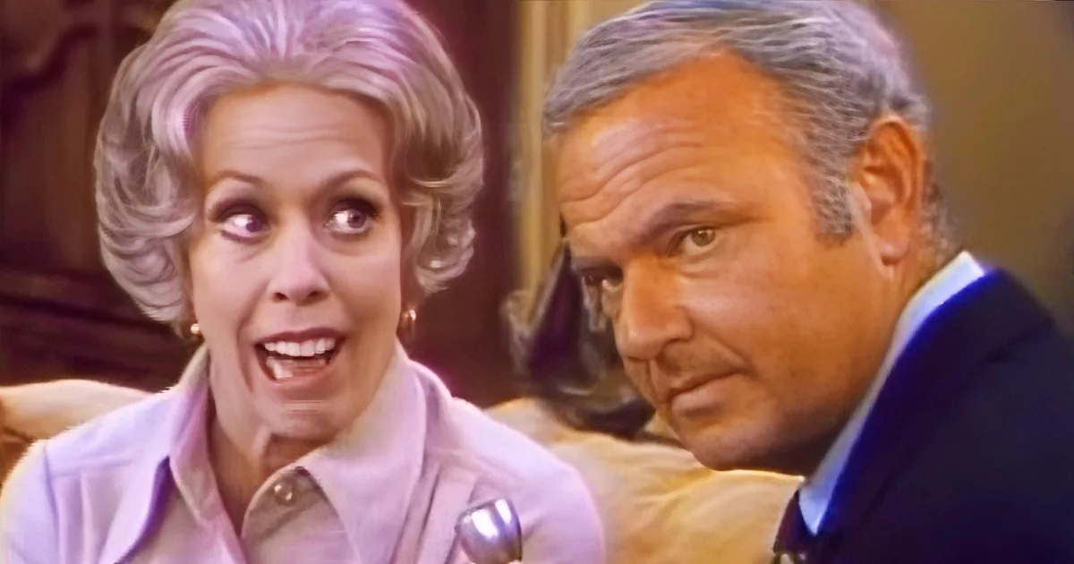 A woman in a light pink blouse is speaking, while a man in a dark suit looks on with a concerned expression.