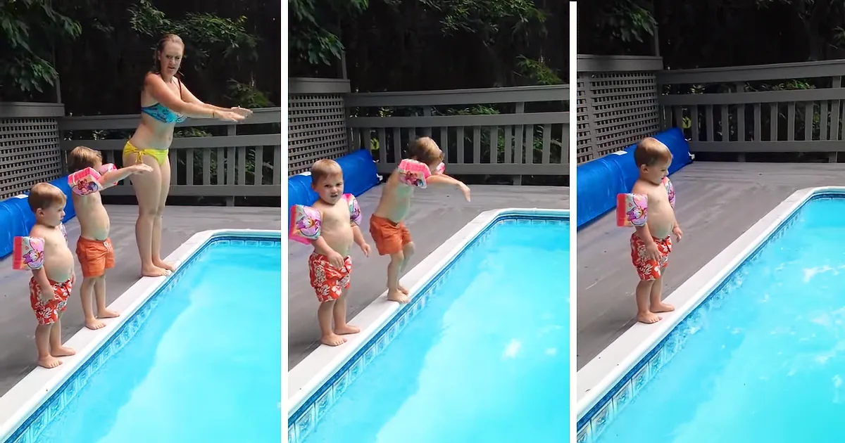 A woman in a bikini stands by a pool with three children, one of whom jumps into the water.