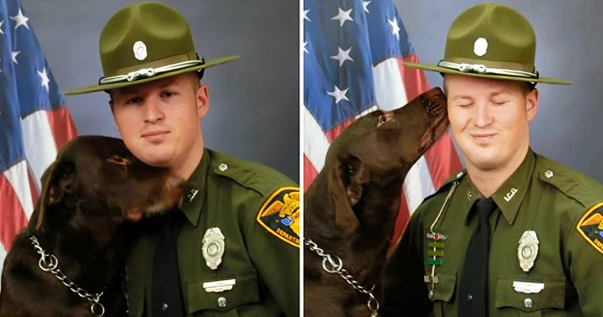 A police officer in uniform poses with a brown dog in front of an American flag.