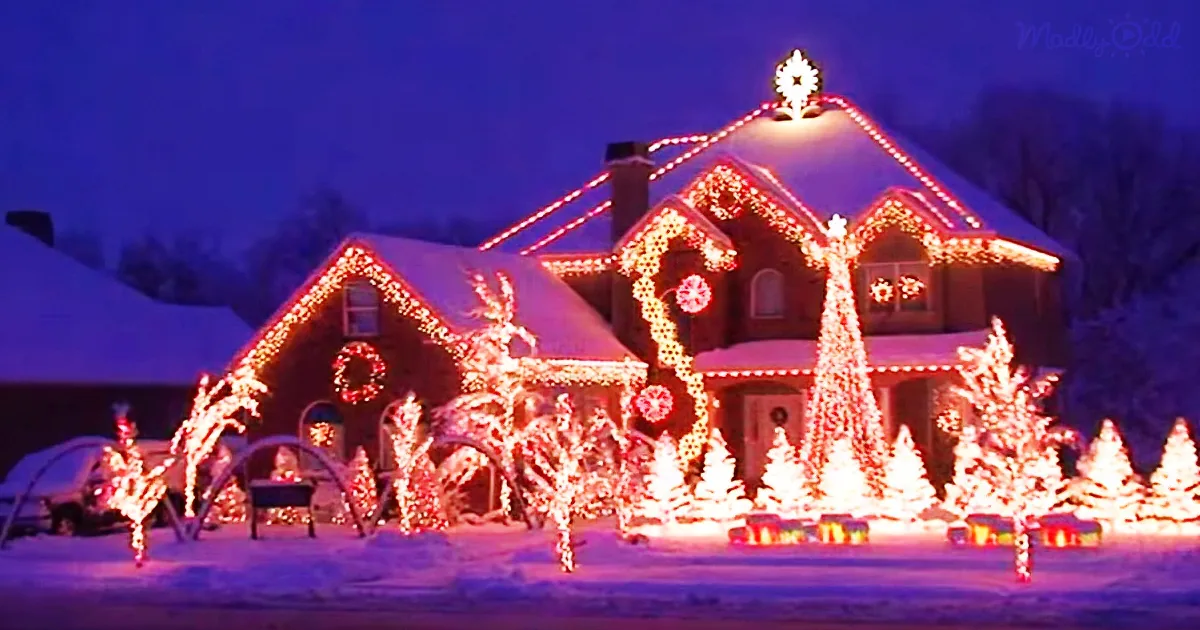 A snow-covered house adorned with festive red lights and decorations, creating a magical holiday scene.