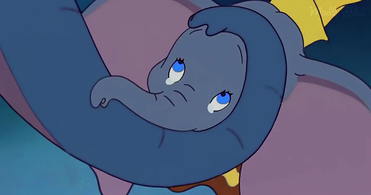 A sad, blue elephant with big eyes and a brown bow tie is looking down.