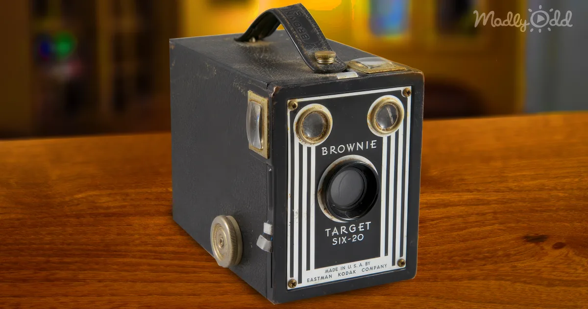 A vintage Kodak Brownie Target Six-20 camera sits on a wooden surface, showcasing its classic design and details.