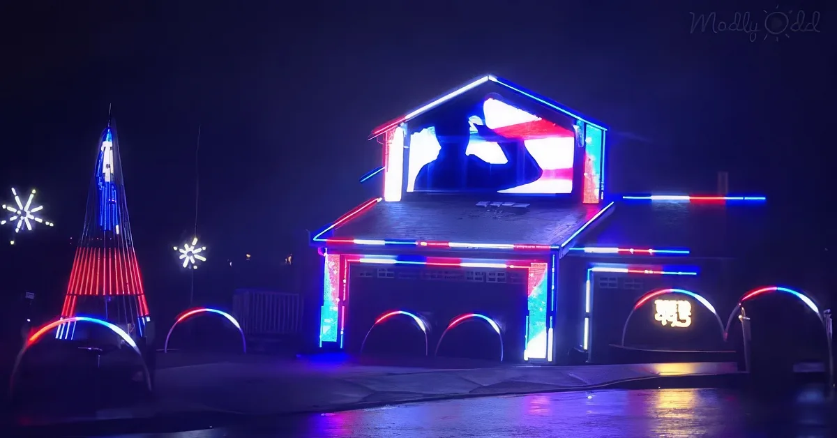A house is adorned with vibrant blue and red lights, creating a festive and colorful display at night.