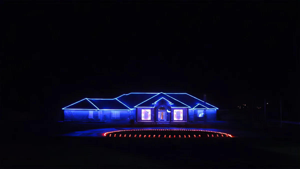 A house illuminated with blue lights at night, surrounded by a circular red light display.