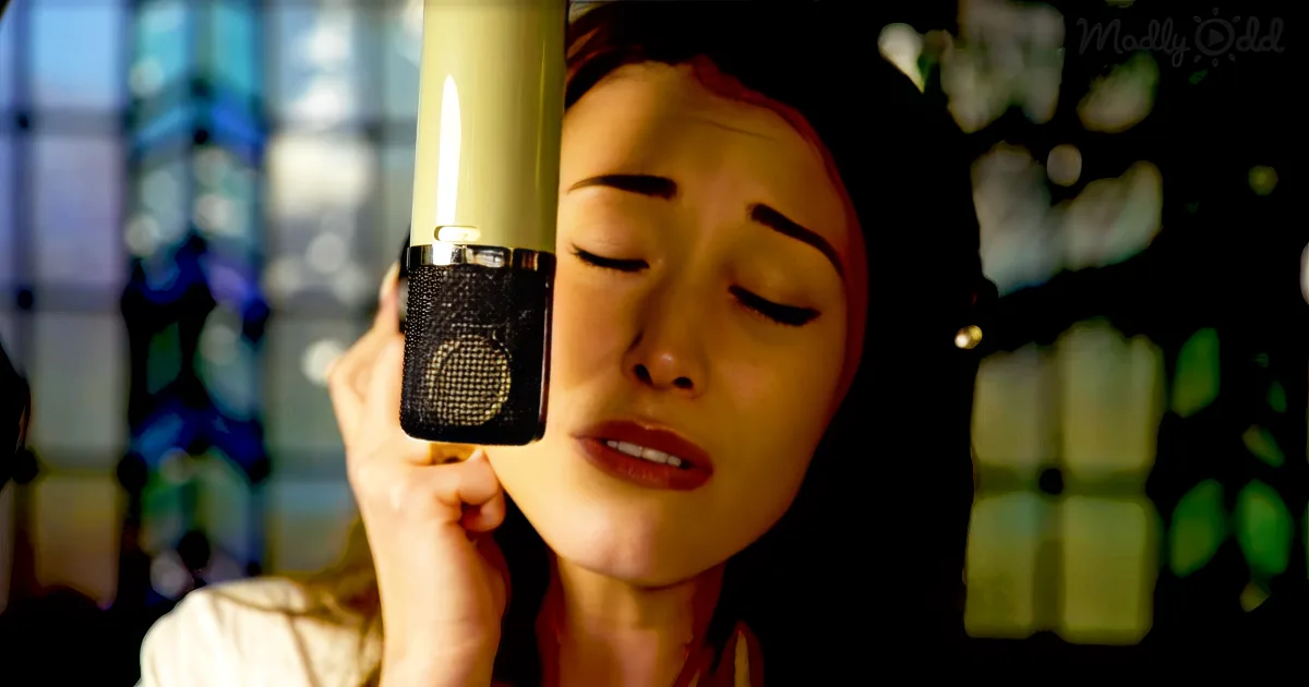 A person singing into a vintage microphone with a blurred colorful background.