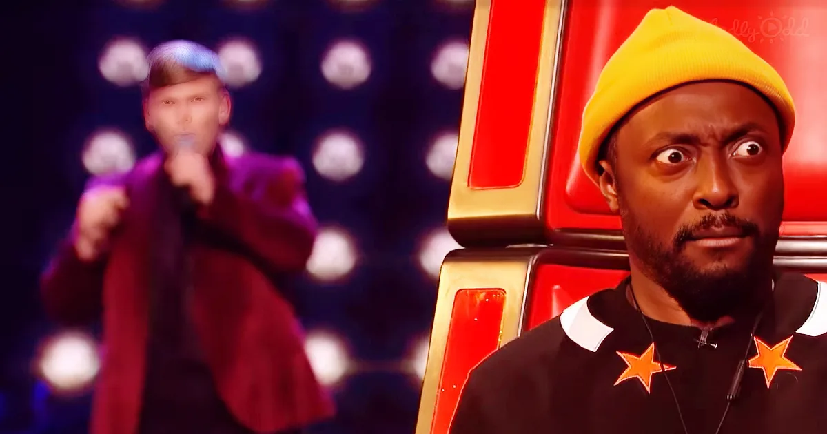 A man in a yellow beanie and black jacket with orange stars sits on a red chair, looking surprised, while another person...