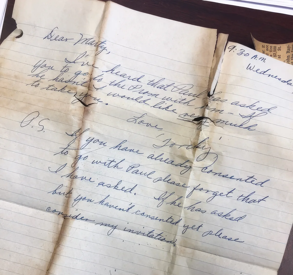 A handwritten note on lined paper expresses concern about a prom invitation and asks for a response.