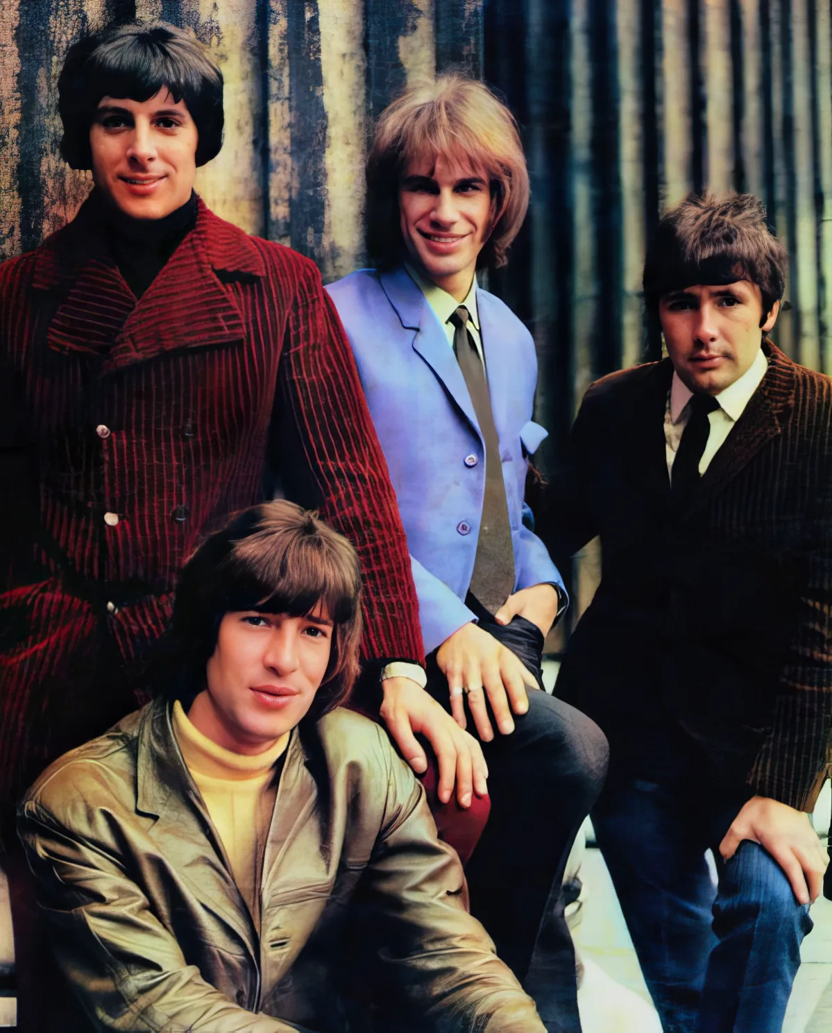 A group of four men in 1960s fashion, posing together in a vintage photo.