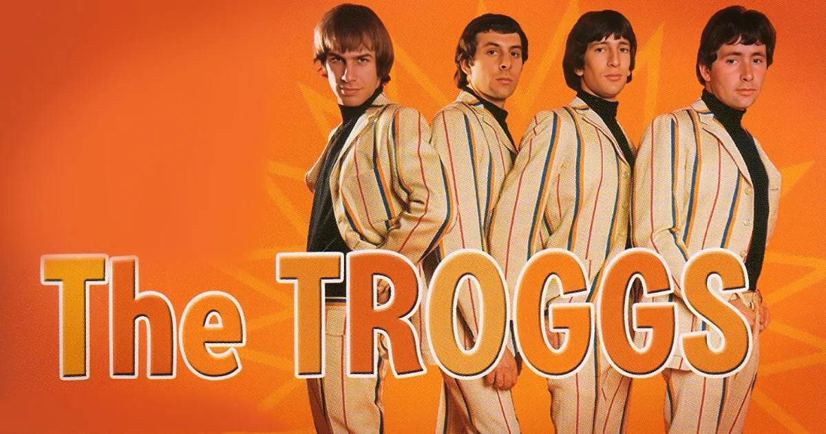 The Troggs band members in striped suits pose against an orange background with their name displayed.