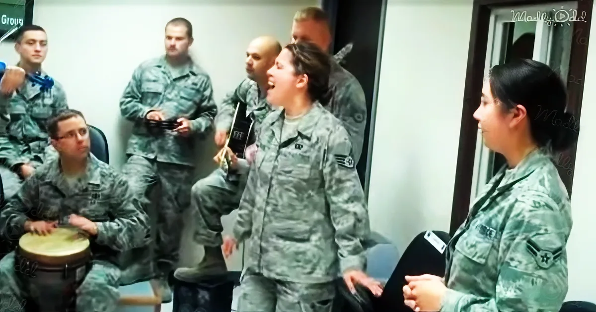 A soldier in uniform sings while playing guitar, surrounded by others in military attire, creating a lively musical moment.