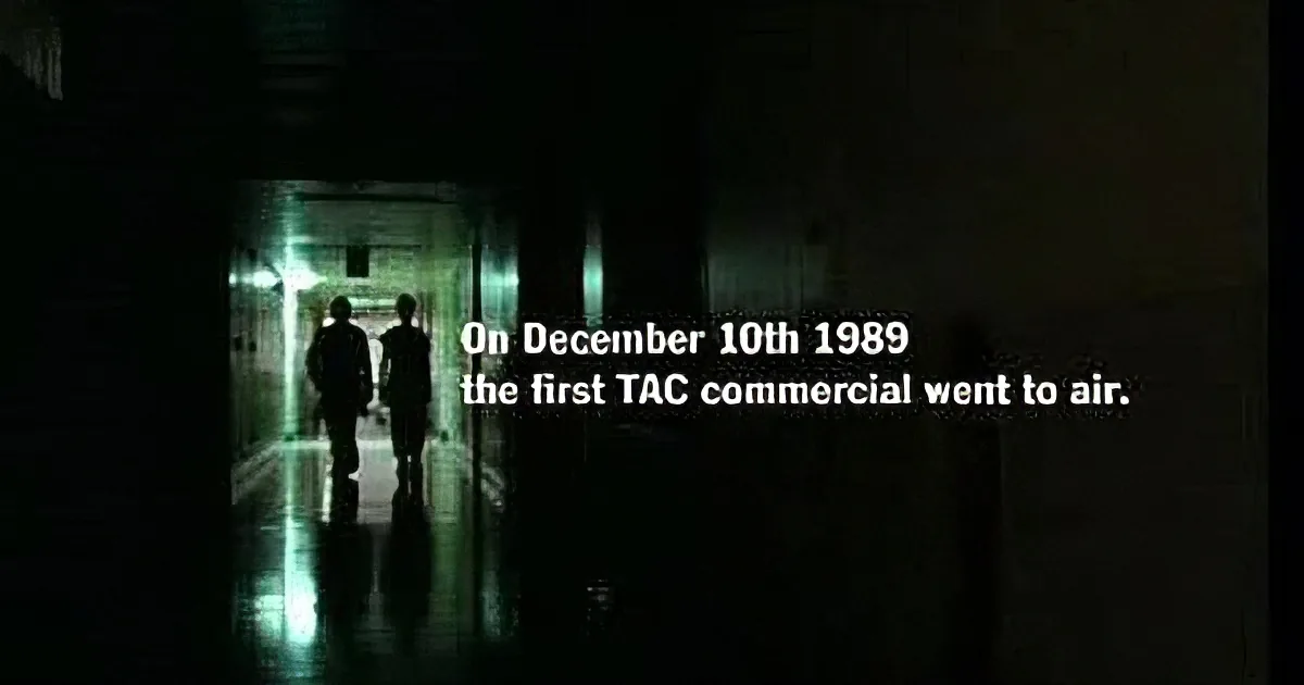 Two figures walk through a dimly lit hallway with text overlay about the first TAC commercial airing on December 10th, 1989.