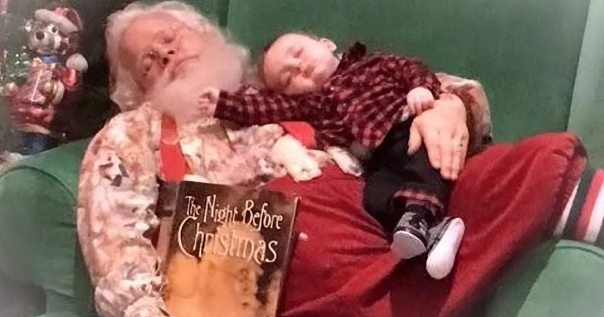 Santa Claus and a child sleep together on a green couch, with Santa holding a book titled "The Night Before Christmas."