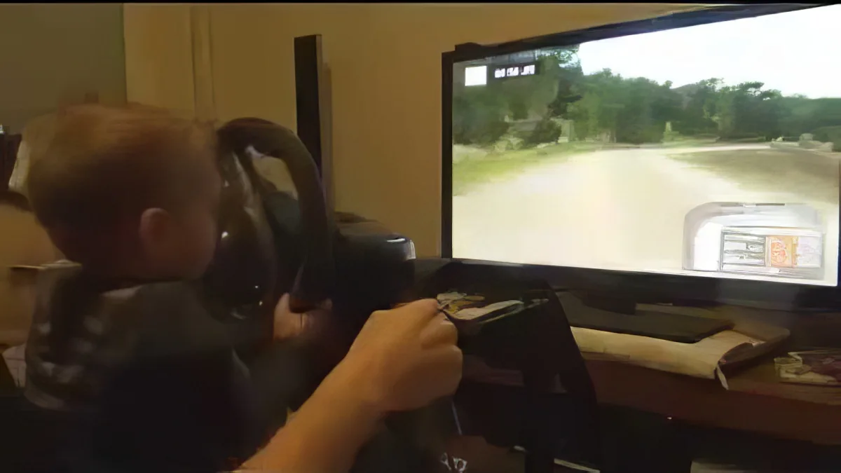 A person is intensely focused on a driving simulation game, holding a steering wheel controller.