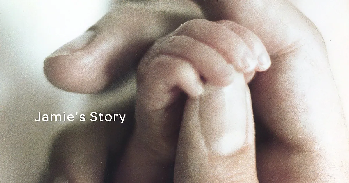 A close-up of a baby's hand being held by an adult's hand.