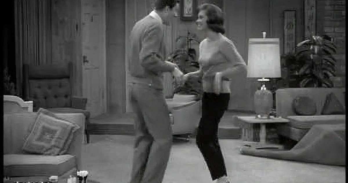 A man and woman are dancing in a living room with vintage furniture and plants.