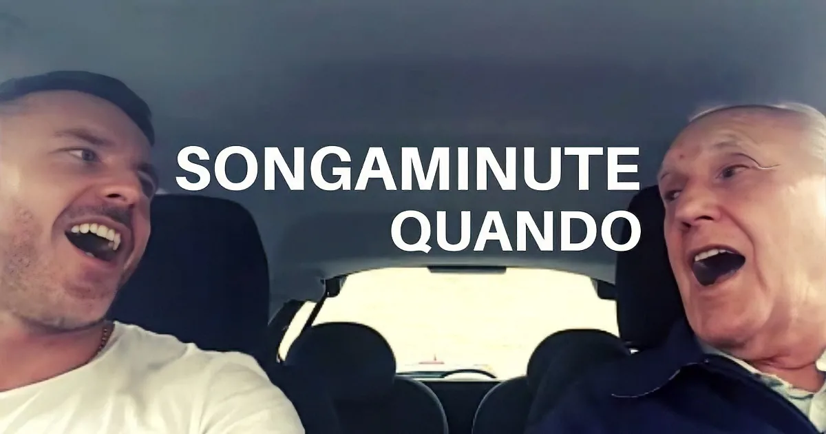 Two individuals in a car, one driving, both singing or laughing, with text "SONGAMINUTE QUANDO" overlaid.