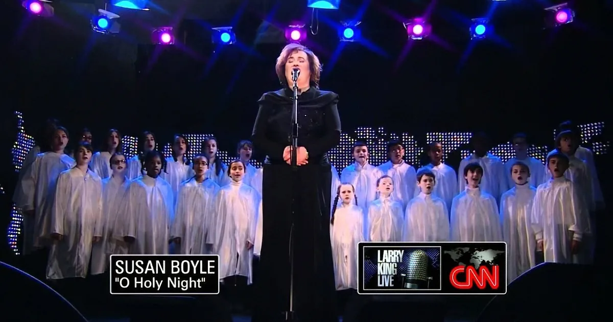 Susan Boyle sings "O Holy Night" on CNN with a choir behind her.