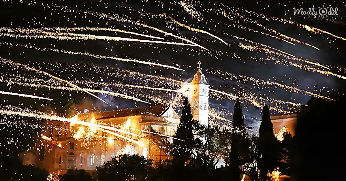 I see a church illuminated by fireworks and lights, creating a festive atmosphere.