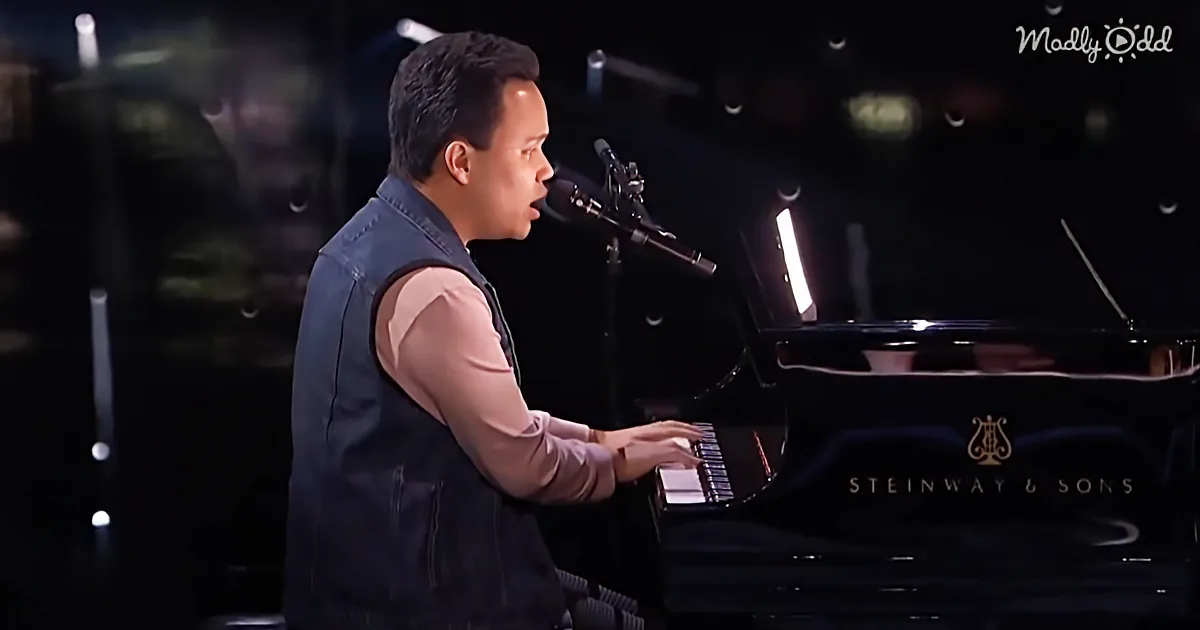 A man in a vest plays a Steinway & Sons grand piano, singing into a microphone.