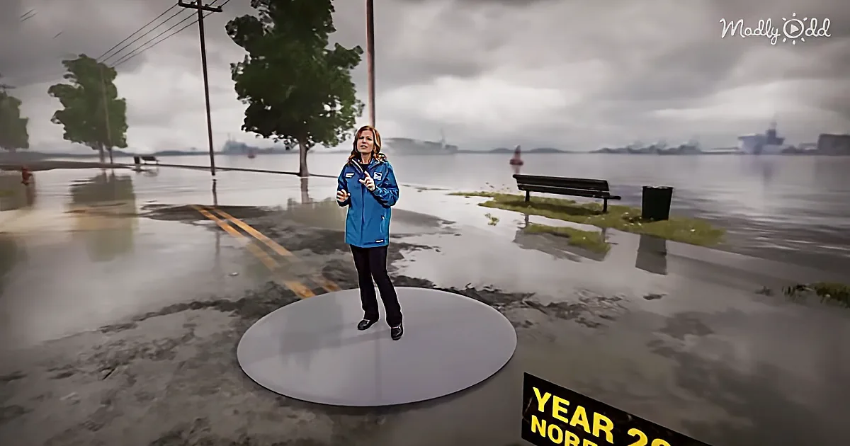 A woman in a blue jacket stands on a circular platform in a flooded street, with a cloudy sky and trees in the background.