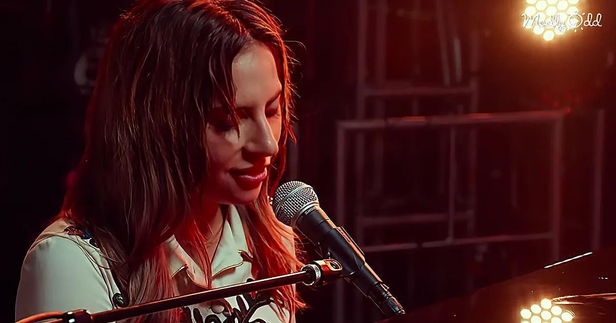 A woman with long hair sings into a microphone, illuminated by red lighting.