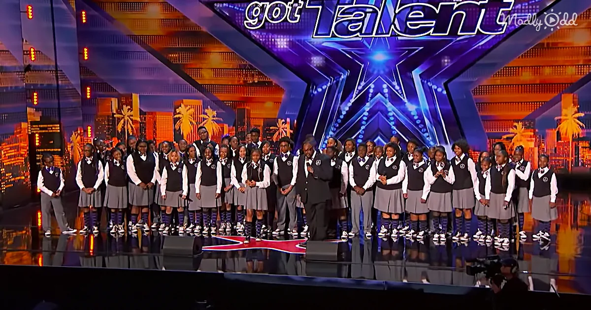 A group of children in school uniforms stands on a stage with a judge, preparing for a performance.
