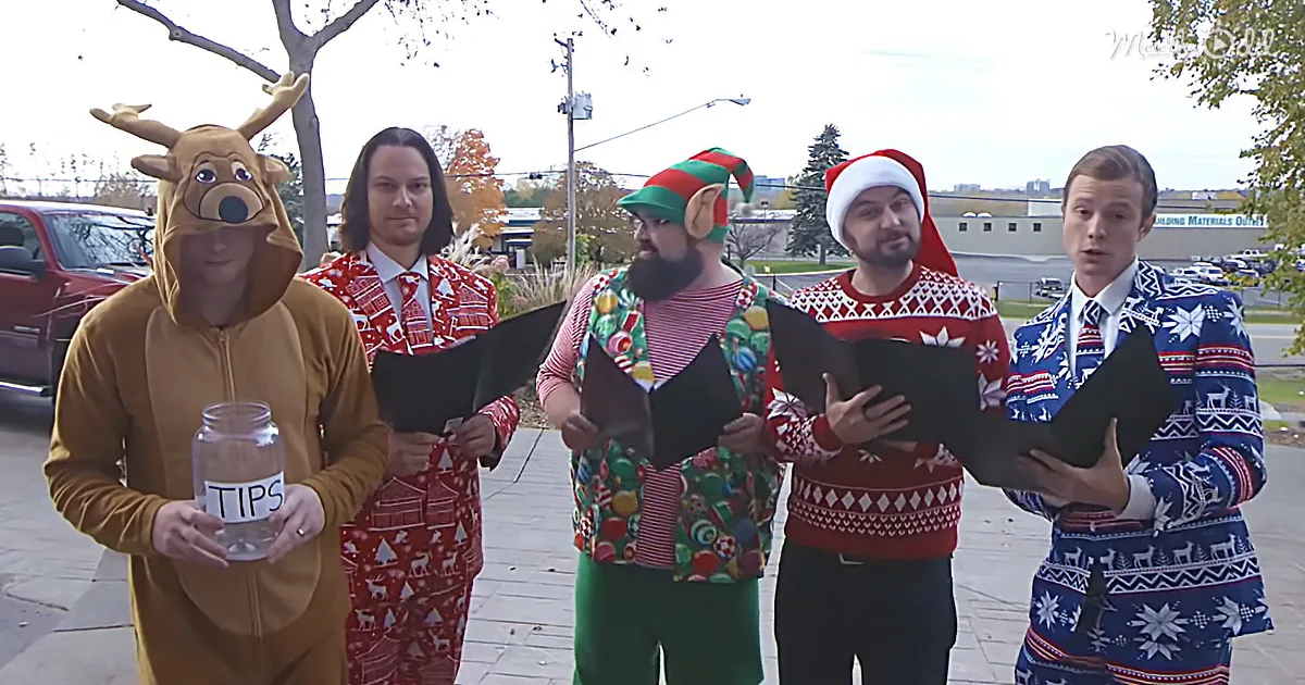 A group of five people dressed in festive holiday attire, including a reindeer costume and Christmas sweaters, are...
