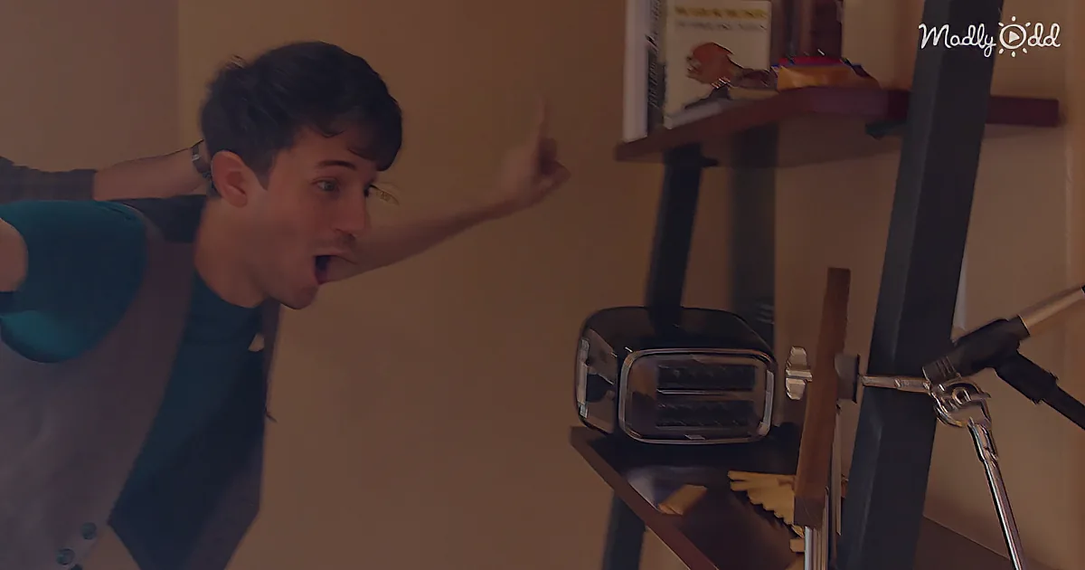 A person in a blue shirt points excitedly towards a toaster on a shelf.