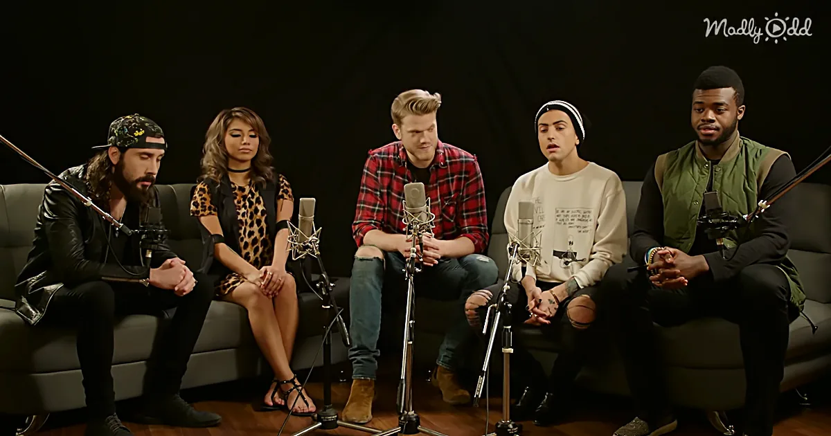 Five people sit on a couch with microphones, seemingly in a recording or interview setup.
