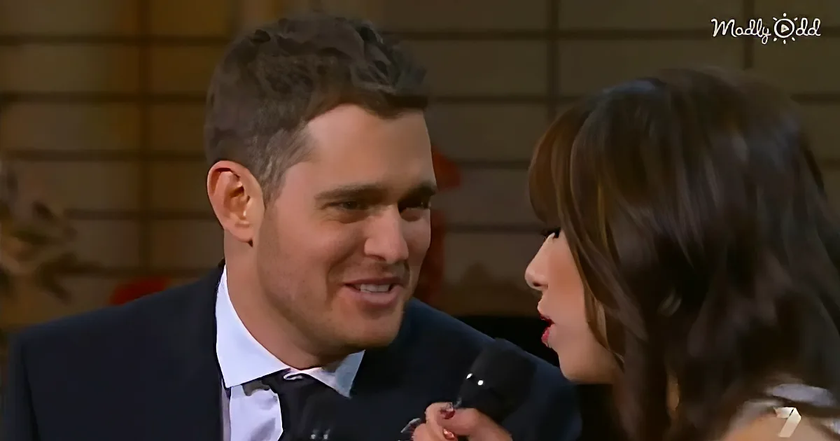 A man in a suit smiles while being interviewed by a woman holding a microphone.