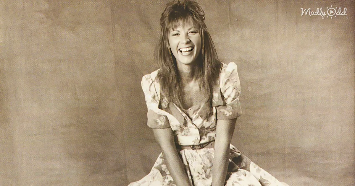 A woman in a floral dress is sitting and laughing, with a sepia-toned background.