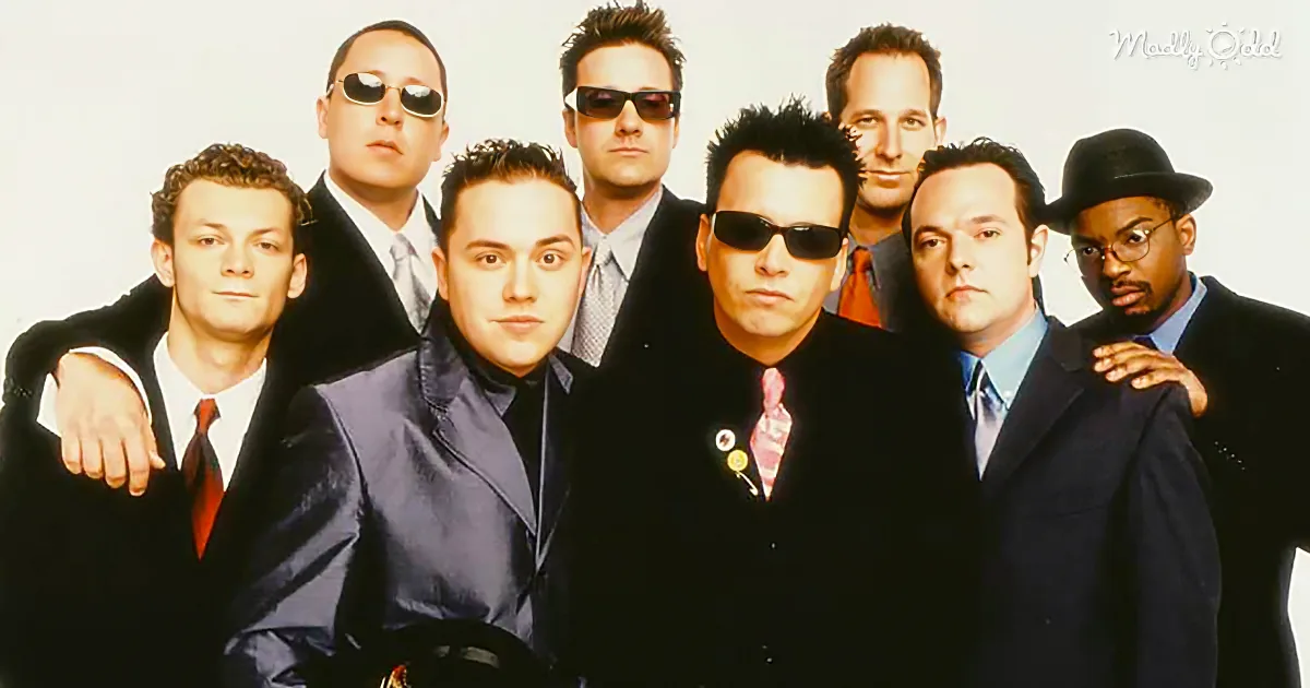 A group of men in suits and sunglasses, posing together in a promotional photo.