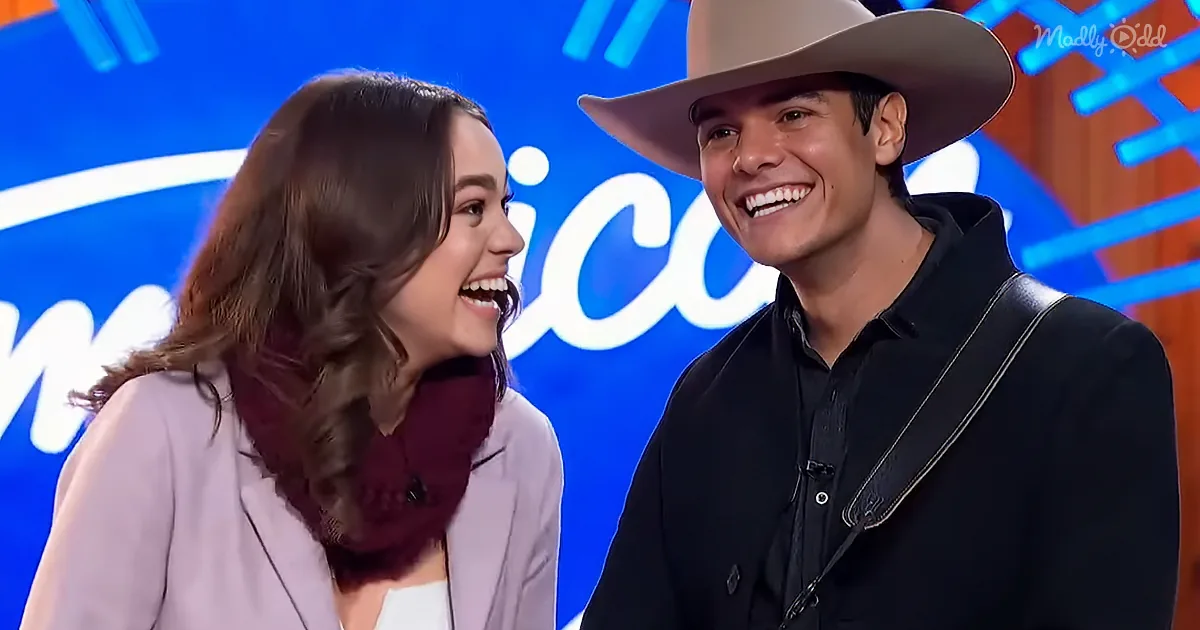 A man in a cowboy hat and a woman in a white blouse share a joyful moment on a stage with a blue background.