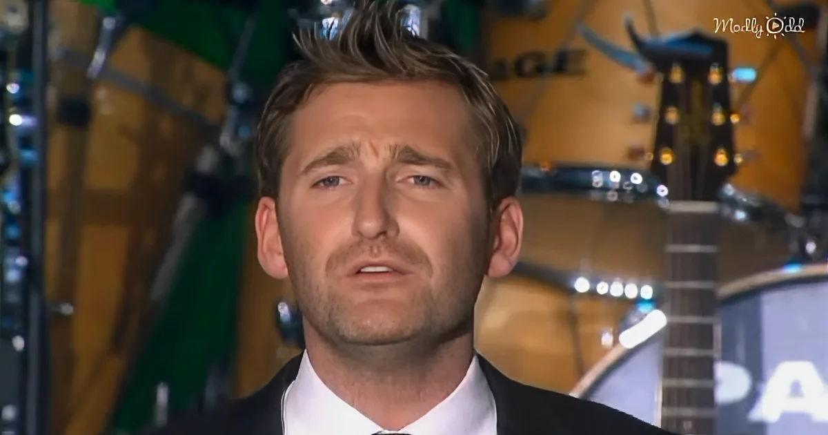 A man in a suit and tie looks concerned, with guitars and equipment in the background.