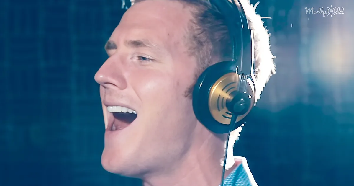 A man wearing headphones and singing passionately, with a microphone visible.