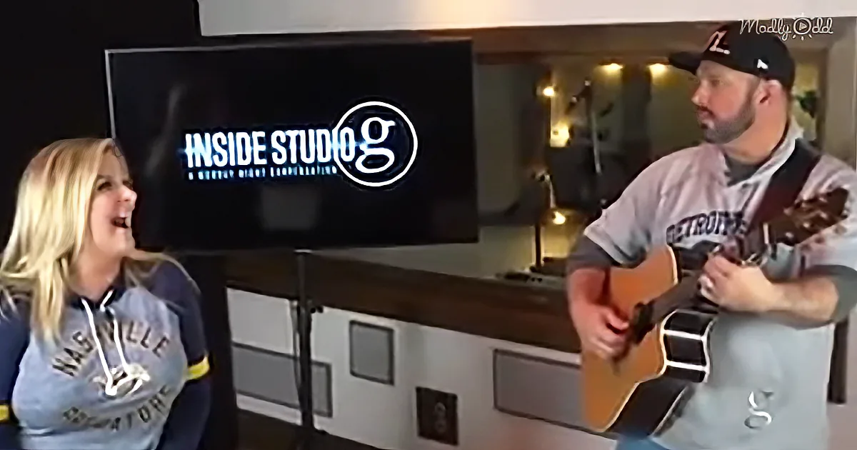 A man plays guitar while a woman laughs in front of a "Inside Studio G" sign.