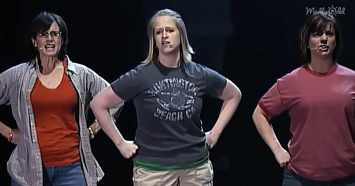 Three women stand with hands on hips, wearing casual clothing, against a dark background.