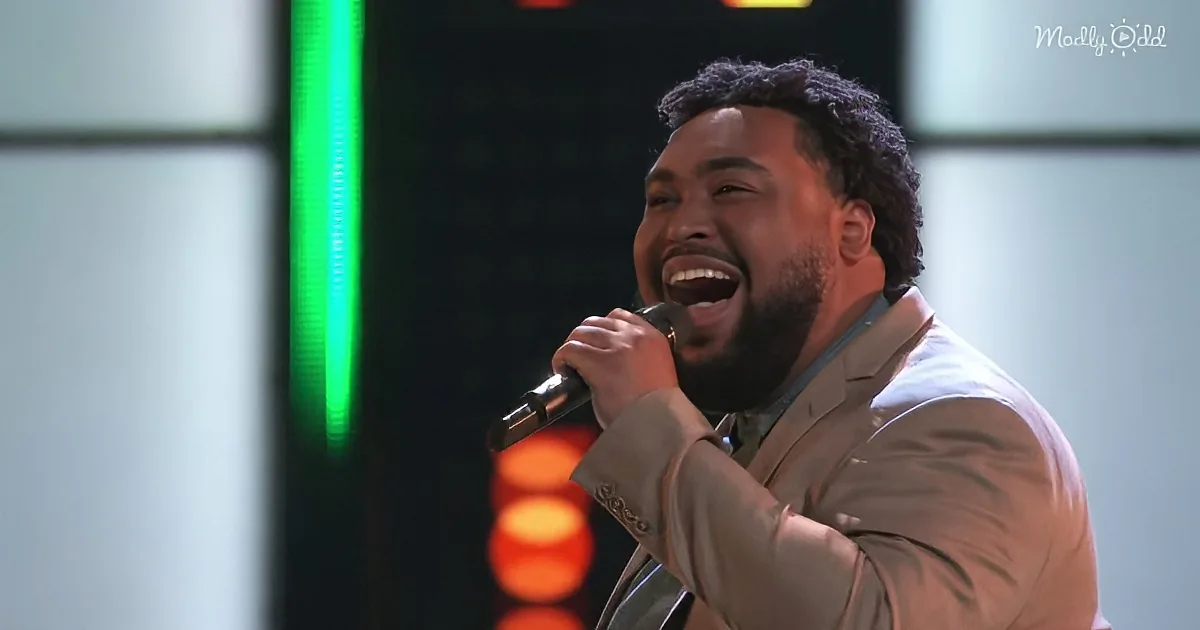 A man in a suit sings passionately into a microphone, his mouth wide open.