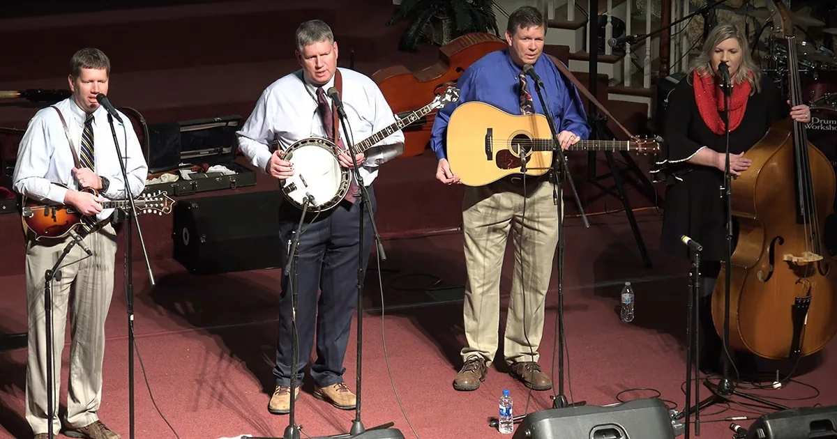 A group of musicians perform on stage with banjos, guitar, and upright bass.