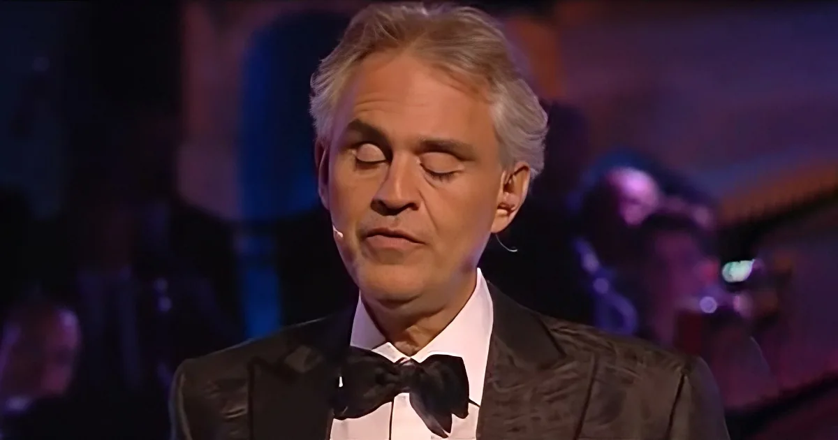 A man in a tuxedo with his eyes closed, possibly singing or in deep thought.