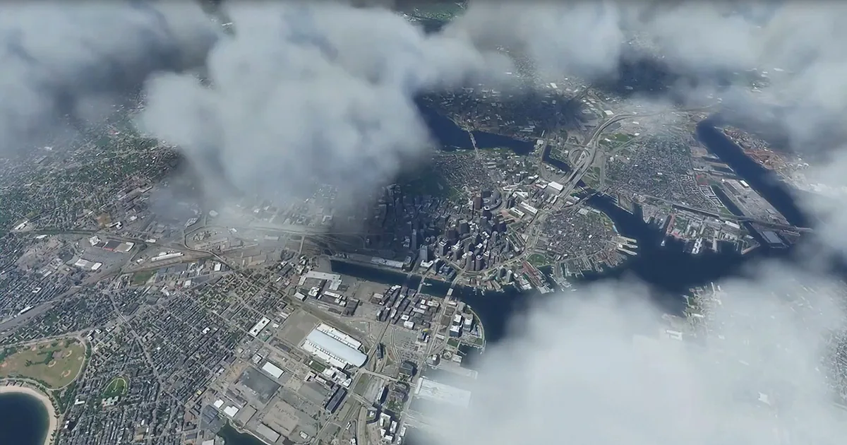 Aerial view of a cityscape with clouds partially obscuring the view, featuring a river and urban infrastructure.